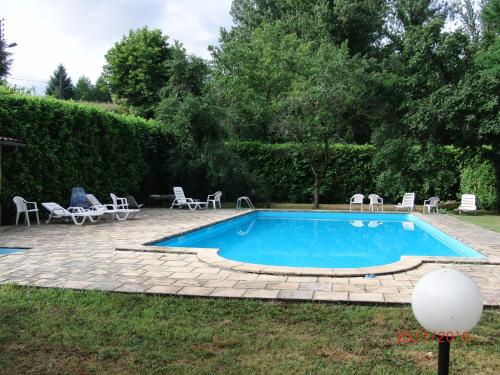 una piscina in un cortile con sedie intorno di Logis - Hotel Restaurant du Parc a Cransac