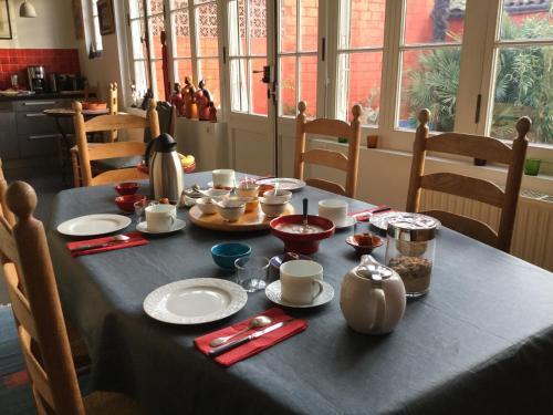 a dining room table with a black table cloth on it at La Ferrade Chambres d'Hôtes B&B in Bègles