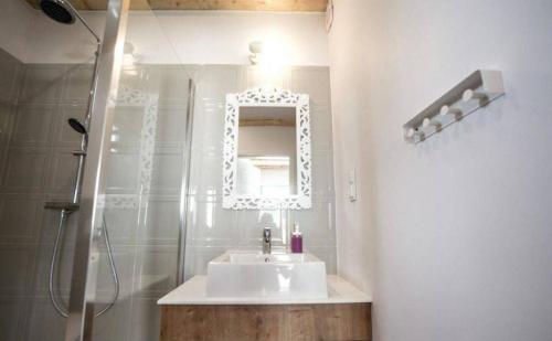 a bathroom with a sink and a shower with a mirror at Domki Osada Kalinowa Nowęcin Łeba Sauna in Łeba