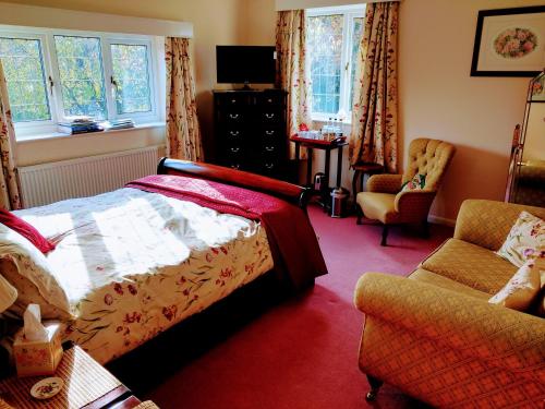 a bedroom with a bed and a chair and windows at Grove House Bed & Breakfast in York