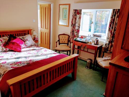 Un dormitorio con una cama, un escritorio y una silla. en Grove House Bed & Breakfast, en York