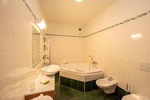 y baño con bañera, aseo y lavamanos. en Hotel Conteverde en Montecchio Emilia