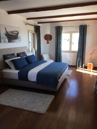 a bedroom with a large bed with blue pillows at Felicidade in Loulé