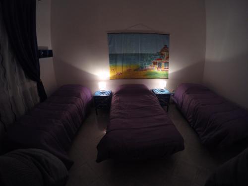 een kamer met 2 bedden en een schilderij aan de muur bij Apartment La Conchiglia in Menfi