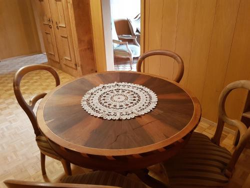 a wooden table with four chairs around it at Ferienwohnung am Bach in Münster