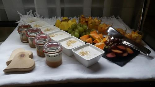 a table with a bunch of food and jars of honey at Hotel Riederhof- Urlaub mit WAU! in Ried im Oberinntal