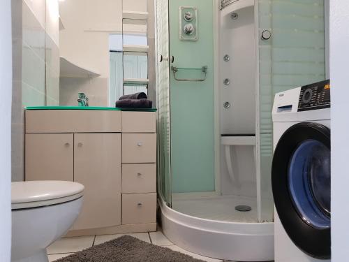 a bathroom with a toilet and a washing machine at Joli T2 à 5 min de la plage in Le Gosier