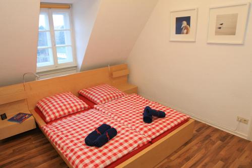a bedroom with a bed with slippers on it at Ferienwohnung INSELVILLA in Hameln
