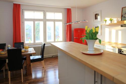 a kitchen with a table and a vase of flowers on a counter at Ferienwohnung INSELVILLA in Hameln