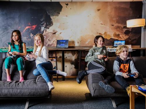 a group of children sitting on couches playing a video game at ArenaHotellet i Uppsala in Uppsala