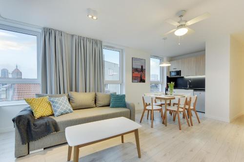 a living room with a couch and a table at Chrobry Apartamenty Gdańsk Grodzka 10 in Gdańsk