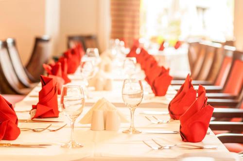 a long table with red napkins and wine glasses at Melas Lara Hotel in Lara