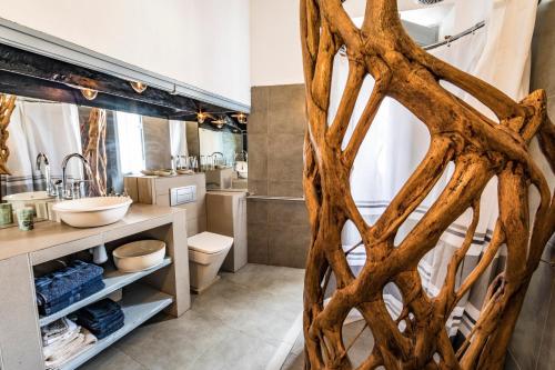 a bathroom with a large wooden tree root wall at El Asiento Del Azar in Banyeres del Penedes