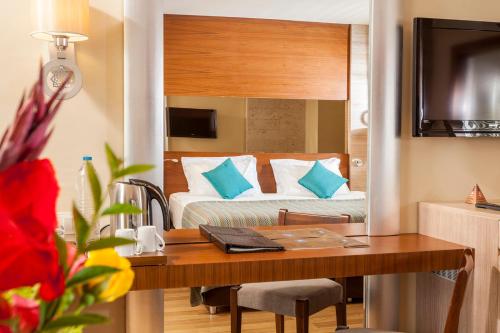 a hotel room with a bed and a desk with a table at Melas Lara Hotel in Lara