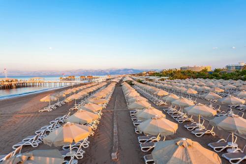 a row of beach chairs and umbrellas on a beach at Melas Lara Hotel in Lara