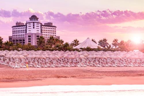 a group of chairs on a beach with a building at Melas Lara Hotel in Lara