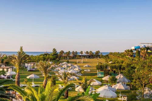 an aerial view of a resort with umbrellas and the ocean at Melas Lara Hotel in Lara