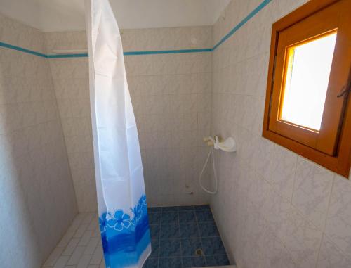 a shower with a clear shower curtain in a bathroom at Caldera View Resort - Adults Only in Akrotiri