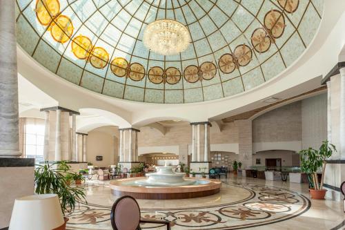 een lobby met een groot glazen plafond en een fontein bij Melas Lara Hotel in Lara