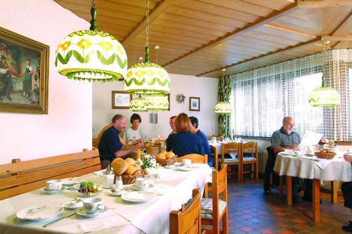un grupo de personas sentadas en una mesa en un restaurante en Akzent Hotel Lawine en Todtnau