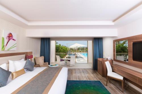 ein Hotelzimmer mit einem großen Bett und einem TV in der Unterkunft Pickalbatros Aqua Blu Sharm El Sheikh in Sharm El Sheikh