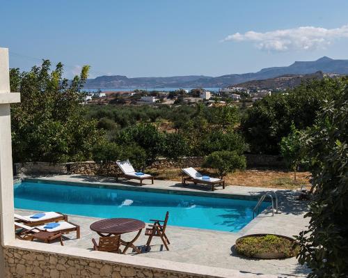 a swimming pool with chairs and a table and chairs at Panorama Villa Private Pool, BBQ, Parking in Sitia