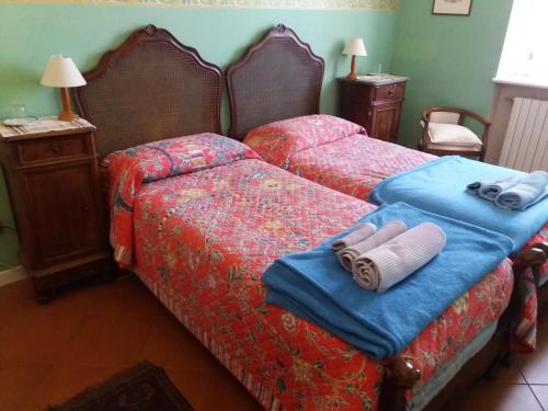 a bedroom with two beds with towels on them at B&B "Angela " in Piacenza