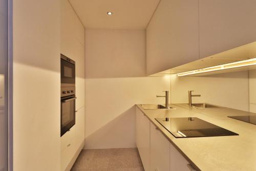 a kitchen with two sinks and a microwave at Appartements Christophorus in Bad Hofgastein