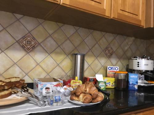 a counter top with a plate of food and bread at B&B mò•sì in Massa dʼAlbe