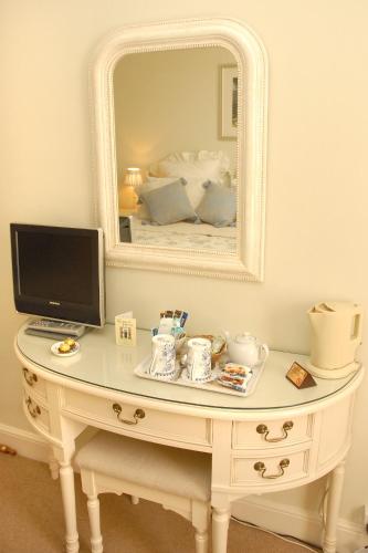 a white dressing table with a television and a mirror at Courtland in Stratford-upon-Avon