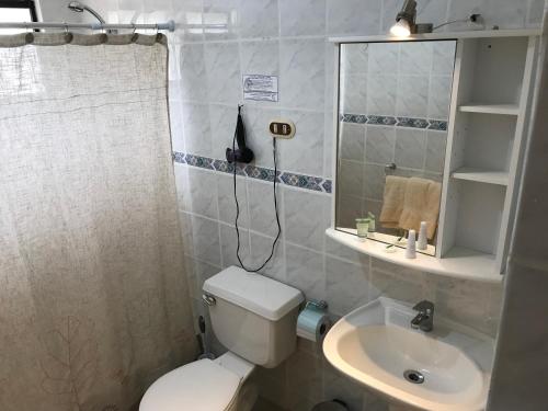 a bathroom with a toilet and a sink and a mirror at Condominio Bahia Inglesa in Bahia Inglesa