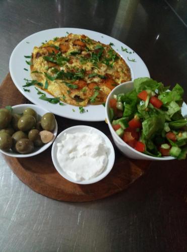 a table with two plates of food and a salad at Cabin Resort in Moshav Ramot