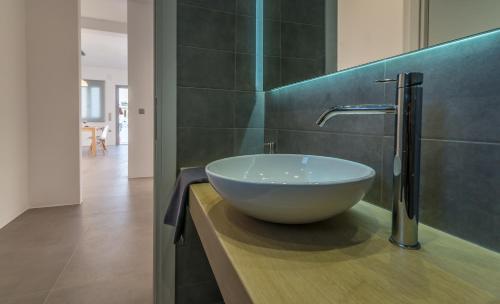 a bathroom with a bowl sink on a counter at Milos Waves Luxury Apartments in Pollonia