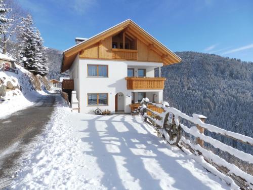 a house in the snow with a fence at Leitnerhof in Terento