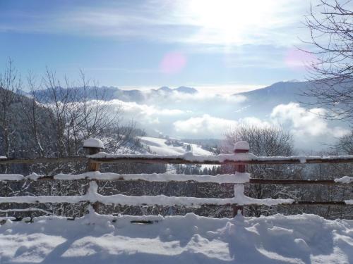 a fence covered in snow with the mountains in the background at Leitnerhof in Terento