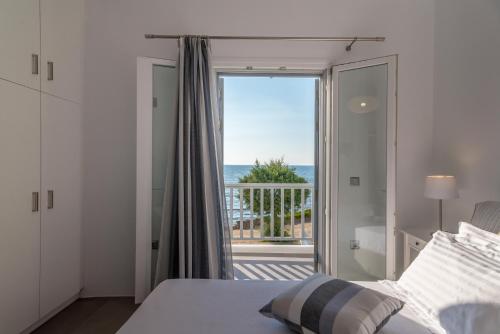 a bedroom with a bed and a view of the ocean at Milos Waves Luxury Apartments in Pollonia