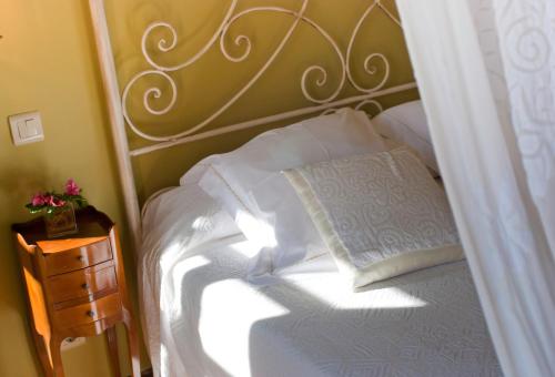 a bedroom with a white bed and a night stand at Casona de San Pantaleón de Aras in San Pantaleón de Aras