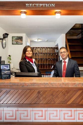 a man and woman standing behind a counter at Hotel Villa d'Amato in Palermo
