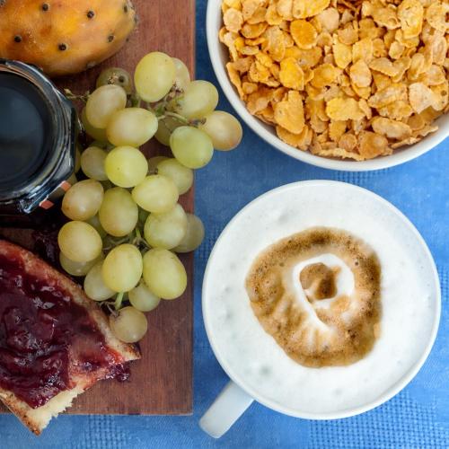 a table with a plate of grapes and a bowl of food at Hotel Villa d'Amato in Palermo