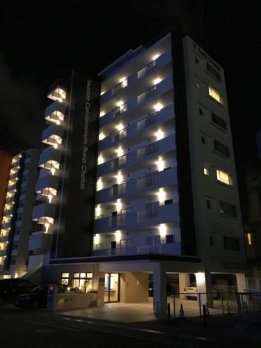 a large building with lights in the night at Seaside Condominium Rana Chatan in Chatan