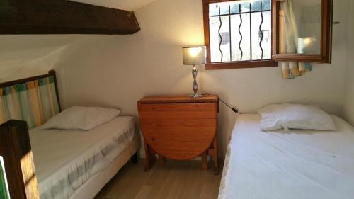 une chambre avec deux lits et une commode et une fenêtre dans l'établissement Résidence Cap Azur Maison N° 56, à Villeneuve-Loubet
