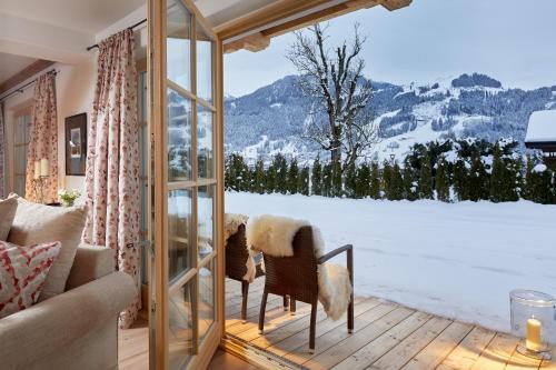 a living room with a window looking out at a snowy mountain at Tennerhof Luxury Chalets in Kitzbühel