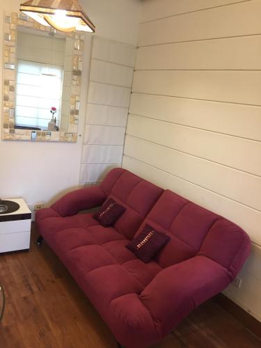 a red couch in a room with a wall at Beautiful Apartments at Tarudhan Valley Golf Resort, Manesar in Gurgaon