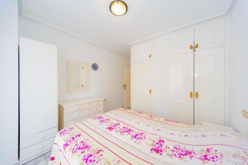 ein weißes Schlafzimmer mit einem Bett und weißen Schränken in der Unterkunft ALEGRIA ID38 in Torrevieja