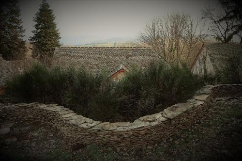 a garden with a stone fence and plants at Domaine des Marequiers le Gite Aigremoine in Saint-Germain-du-Teil