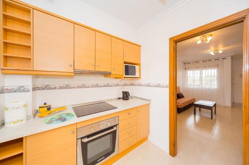 a kitchen with wooden cabinets and a counter top at ALEGRIA ID51 in Orihuela Costa