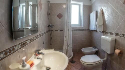 a bathroom with a sink and a toilet and a mirror at Braut in Krk