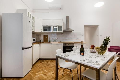 ブダペストにあるThe RUBI apartmentのキッチン(白い冷蔵庫、テーブル、椅子付)