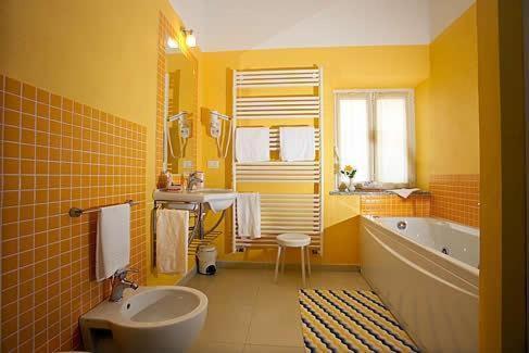 a yellow bathroom with a tub and a sink at Borgo San Martino in Bra