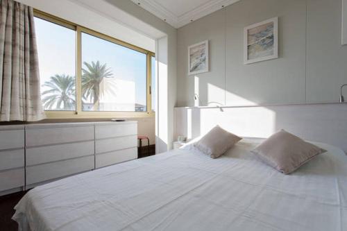 sypialnia z dużym białym łóżkiem i oknem w obiekcie Residence Saint Marc w Cannes